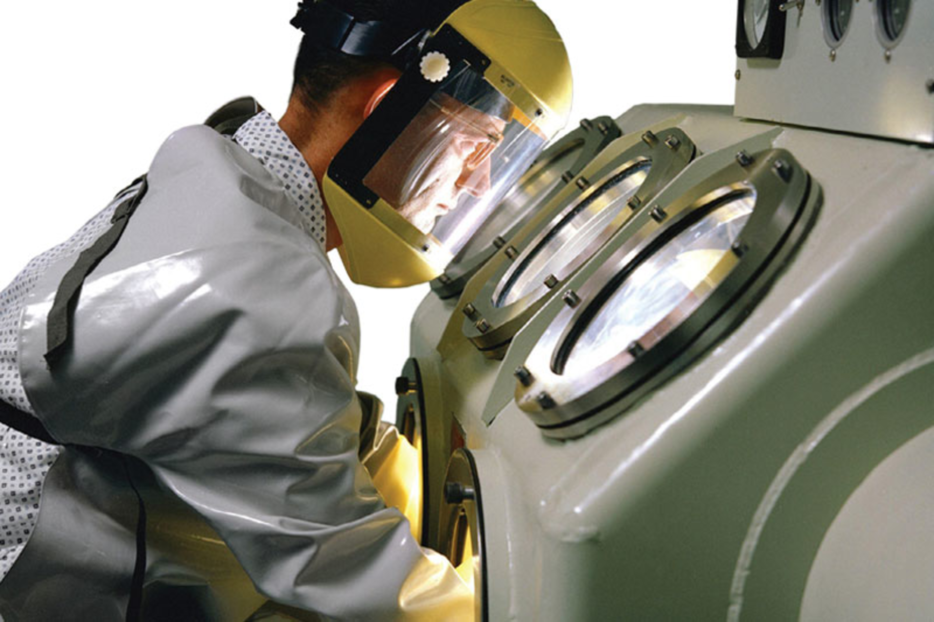 A 1962 photo shows the use of a glovebox for handling sensitive materials. Image courtesy of NASA
