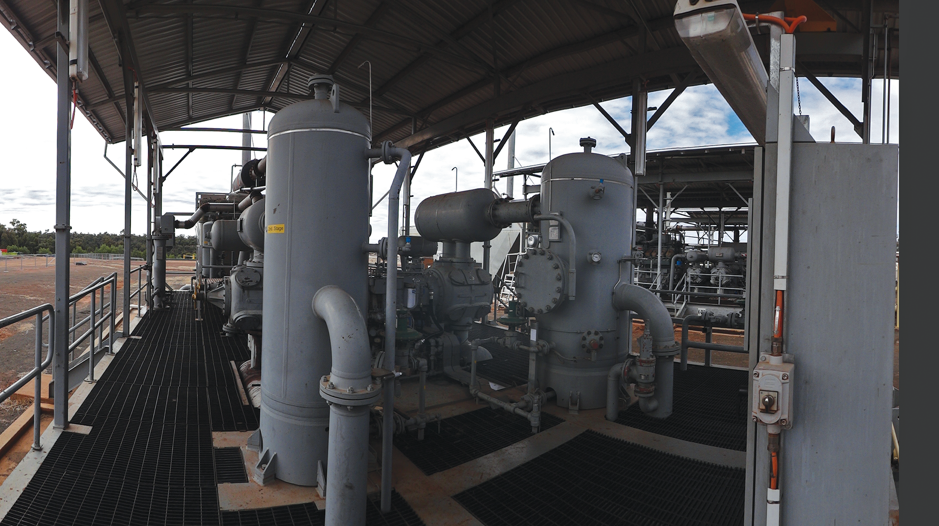 An example of a reciprocating compressor package with pulsation vessels (horizontal pulsation bottles at top and bottom of cylinders), auxiliaries and piping.