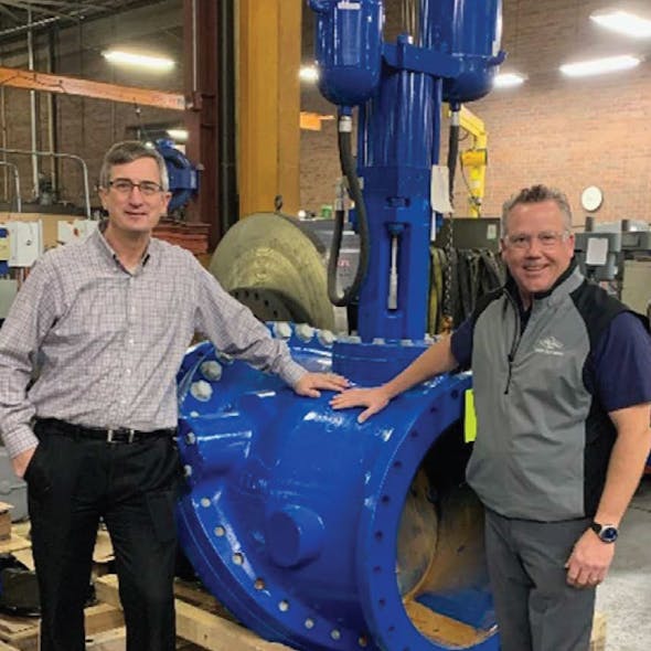 John Ballun and Rob McDonald standing next to a 30&apos; Tilted Disc Check Valve at Val-Matic&rsquo;s Elmhurst facility.